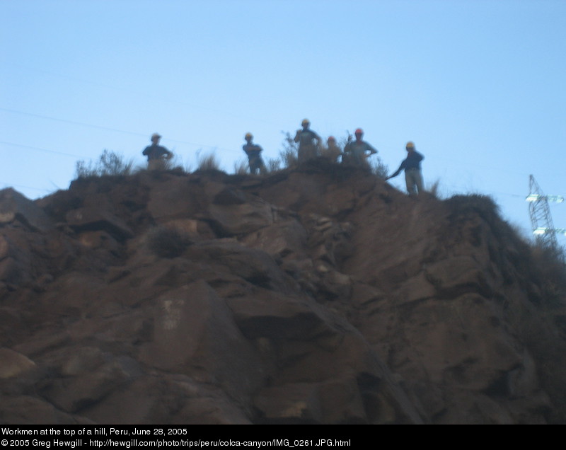 Workmen at the top of a hill