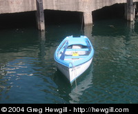 A dinghy floating idly by the docks.