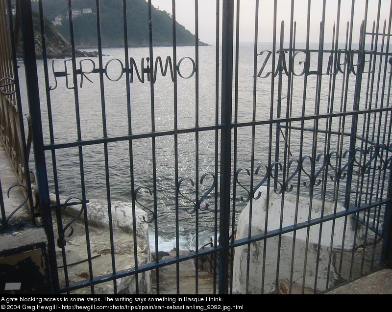 A gate blocking access to some steps. The writing says something in Basque I think.