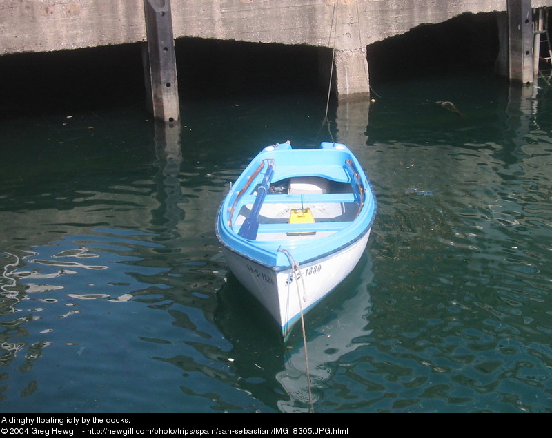 A dinghy floating idly by the docks.