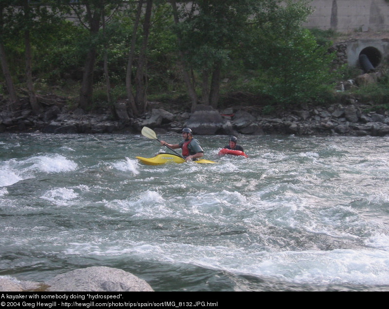 A kayaker with somebody doing "hydrospeed".